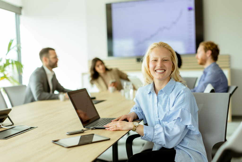 Radiant professional woman smiling during a productive boardroom meeting on a sunny afternoon